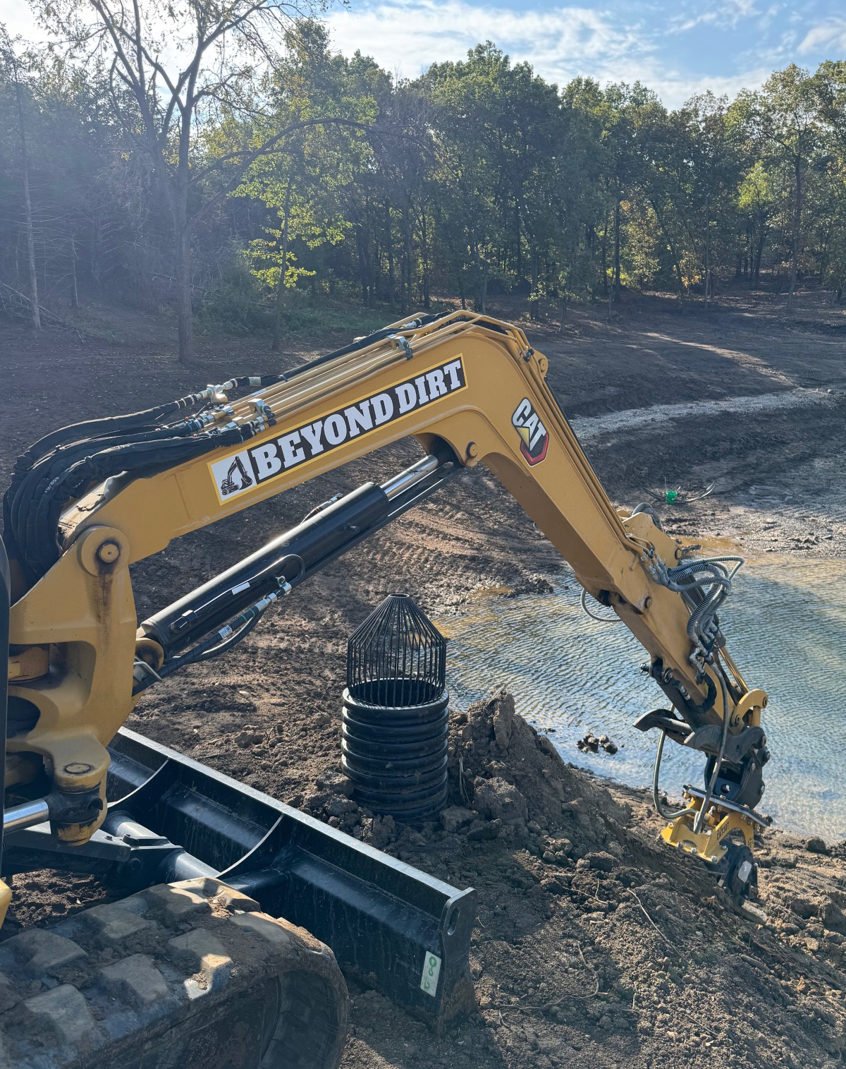 Beyond Dirt branded CAT mini excavator working erosion control project