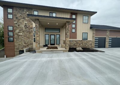 Concrete driveway and entry walkway in front of large two story home