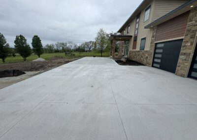 Concrete driveway and entry walkway in front of large two story home