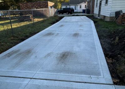Concrete driveway with home and garage in background